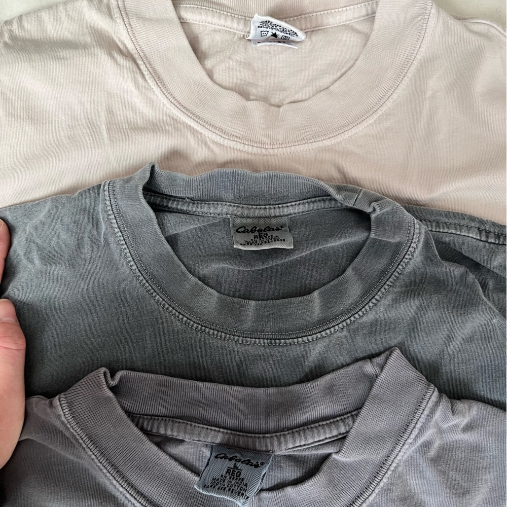 Three (3) Cabela’s men’s t-shirts, size L. Tan, faded blue indigo, faded gray